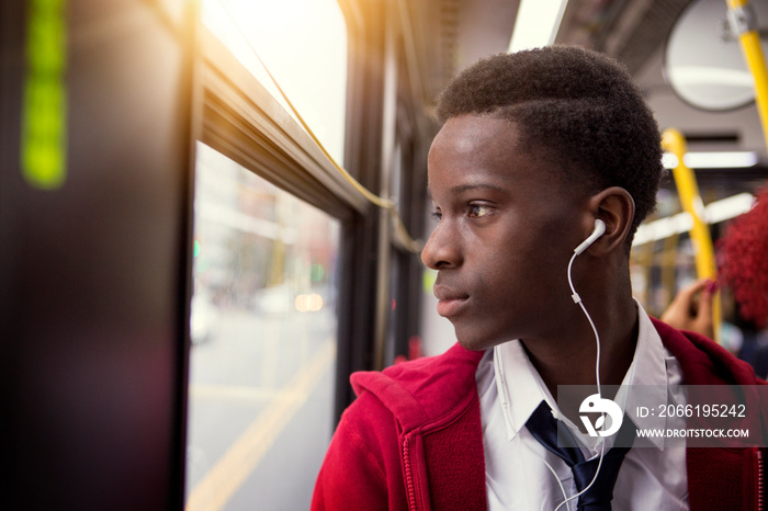 Boy looking out window while travelling by bus