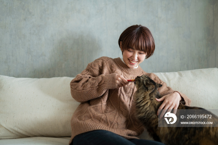 猫におやつをあげる女性