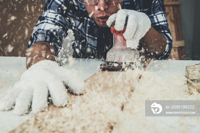 Carpenter working on wood craft at workshop to produce construction material or wooden furniture. Th