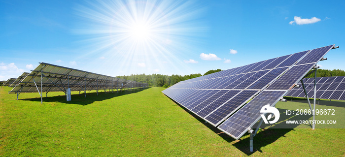 Solar energy panels on the meadow with sunny sky. Sustainable resources.