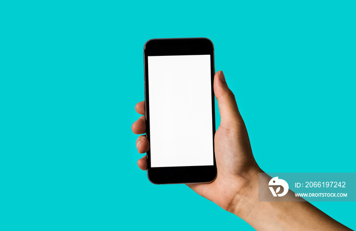 Hand holding white mobile phone with blank white screen Dark Turquoise background.