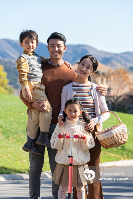 年轻夫妻带着孩子们在玩滑板车