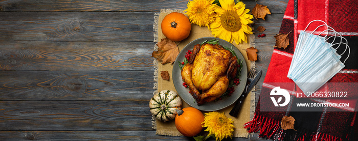 Roasted chicken or turkey for Thanksgiving Day, red blanket, autumn decorations, protective mask, top view. Concept Thanksgiving in pandemic covid, celebrated Thanksgiving outdoors