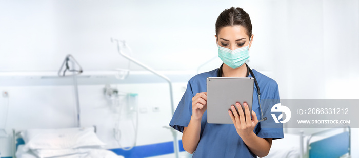 Masked nurse doctor using a tablet