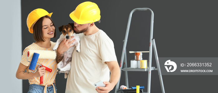 Young couple with cute dog making repair in room