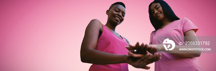 Composite image of two black women joining hands