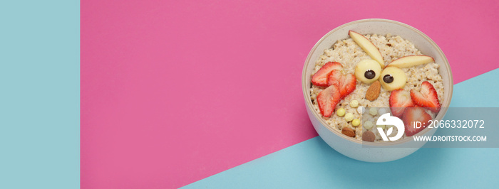 Creative oatmeal breakfast for kids on colourfull background.