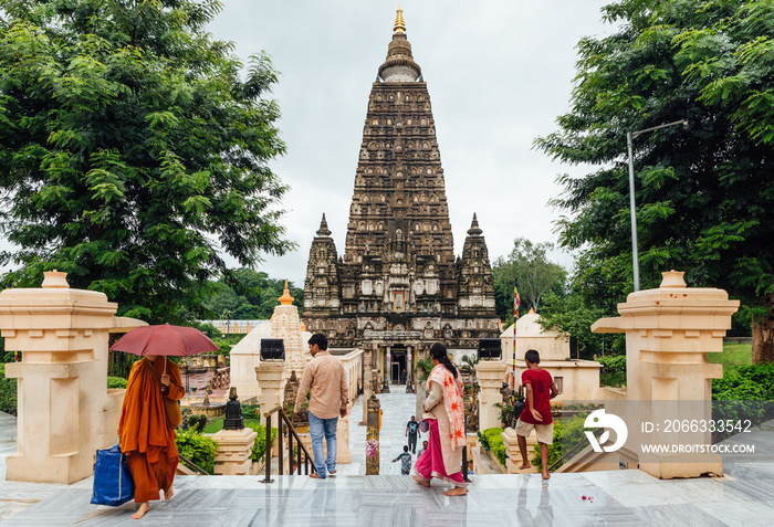 Indian people walking on bare foot to Mahabodhi Temple for praying and pilgrim while raining at Bodh Gaya, Bihar, India