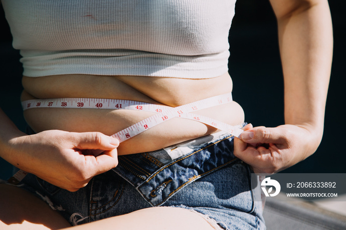 fat woman, fat belly, chubby, obese woman hand holding excessive belly fat with measure tape, woman diet lifestyle concept