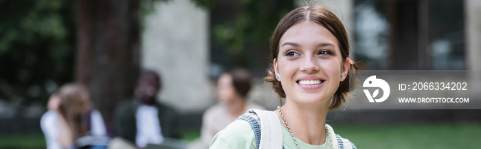 Positive student with backpack standing outdoors, banner