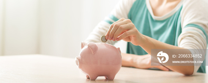 woman hand putting money coin into piggy for saving money wealth and financial concept