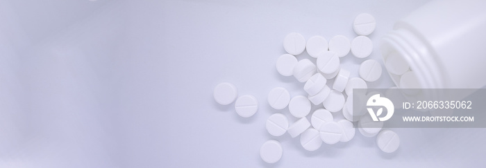 Top view White pills spilling out of pill bottle on isolated white background with copy space