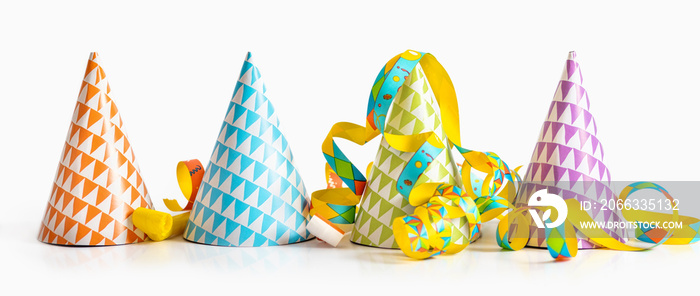 Colorful party decoration. Paper birthday hats and streamers on a white background