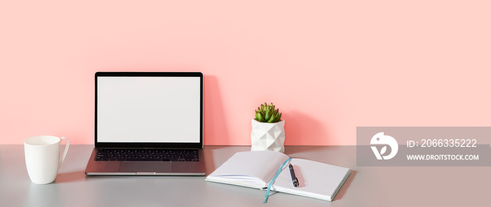 concept of business, work from home, freelance, copywriting, front view of laptop and open notebook with blank pages on pink background.