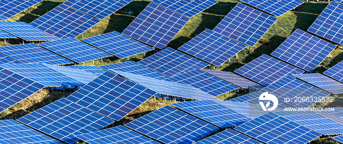 close up of solar panels on uneven ground in the field