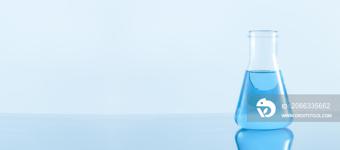 Laboratory glassware with blue liquid on white background