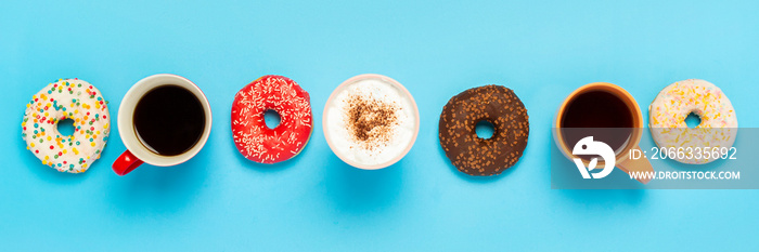 Tasty donuts and cups with hot drinks, coffee, cappuccino, tea on a blue background. Concept of sweets, bakery, pastries, coffee shop, meeting, friends, friendly team. Banner. Flat lay, top view