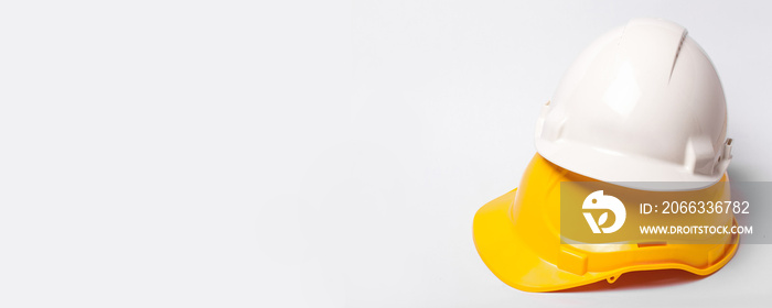 Yellow and white protection helmets isolated on white. Construction site engineer and worker head safety horizontal background with empty copy space.