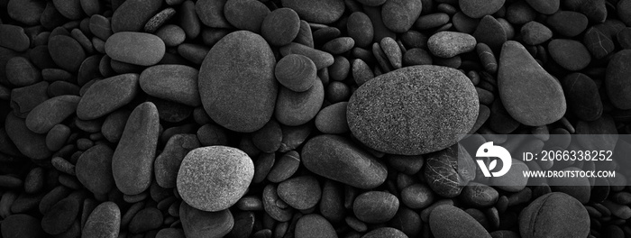 Dark black abstract smooth round pebbles sea texture background