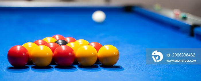 Pool table set up with yellow and red snooker balls