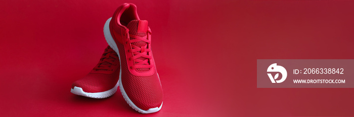 Close-up of red sneakers on bright backdrop. Sport footwear for running and fitness. Amazing pair of shoes. Active lifestyle. Nice texture with white sole and laces