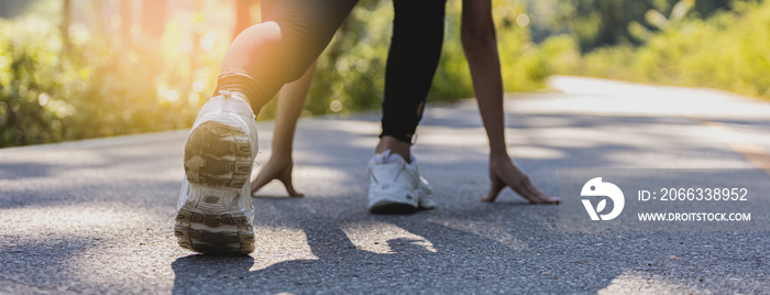 Woman sitting and getting ready to start jogging, she is running in a park where many people come to jogging in the morning and evening, running is a popular activity. Health care concept with jogging