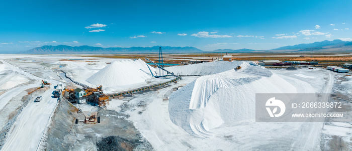 Salt Lake City, Utah landscape with desert salt mining factory at lake Bonneville with piles of white mineral and industrial equipment