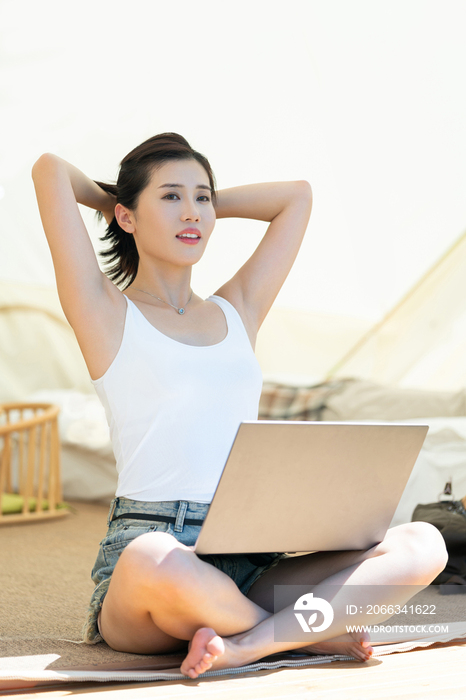 女孩坐帐篷里使用电脑