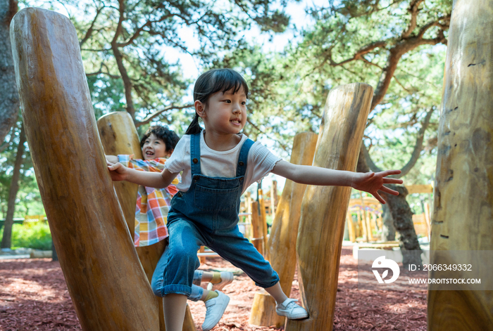 两个小孩子一起走木桩