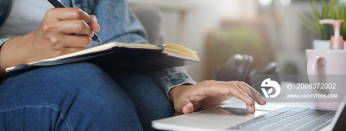 Asian people study online course via internet. Young girl watching business lesson from laptop computer and note lecture to notebook at home.