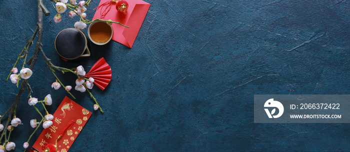 Traditional Chinese tea with red envelopes and blooming plum branches on dark background with space for text