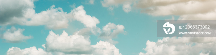 Background of a blue sky with large white clouds. Summer atmospheric background. Warm saturated colors. Banner