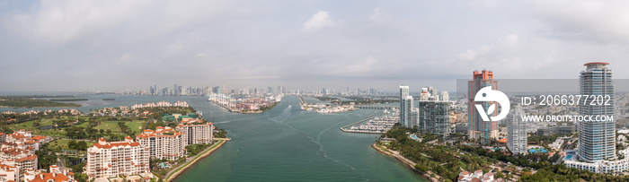 Beautiful aerial panorama overlooking the shipping channels between Miami, Miami Beach and Fisher Island with clouds in the sky above.