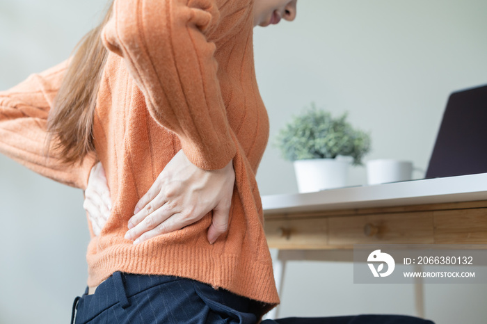 office syndrome, woman with back pain symptoms during work in the office.