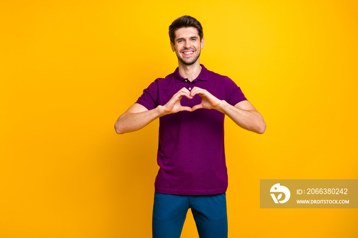 Portrait of his he nice attractive cheerful cheery guy wearing violet shirt showing heart symbol med