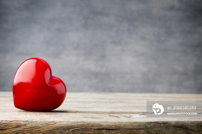 Red heart on the gray metal background.