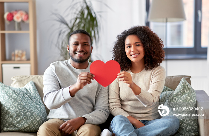 love, valentines day and relationships concept - happy african american couple holding red heart tog