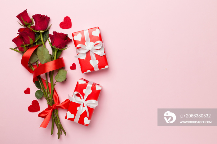 Valentines day gift box with red roses on color background, top view