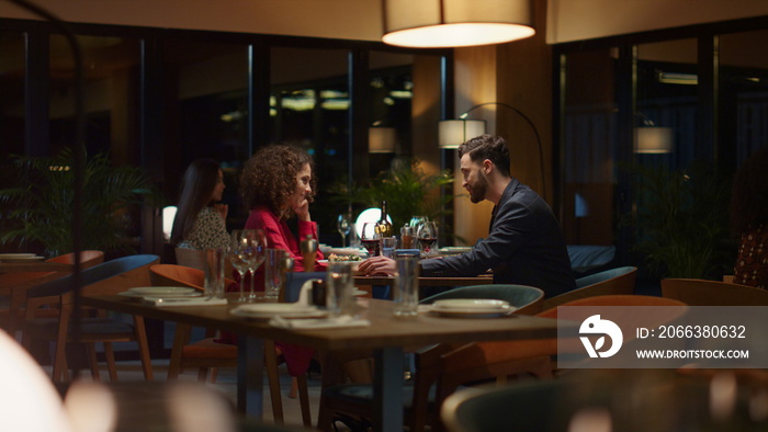 Elegant couple sitting restaurant at evening. Mixed race lovers dating in cafe.