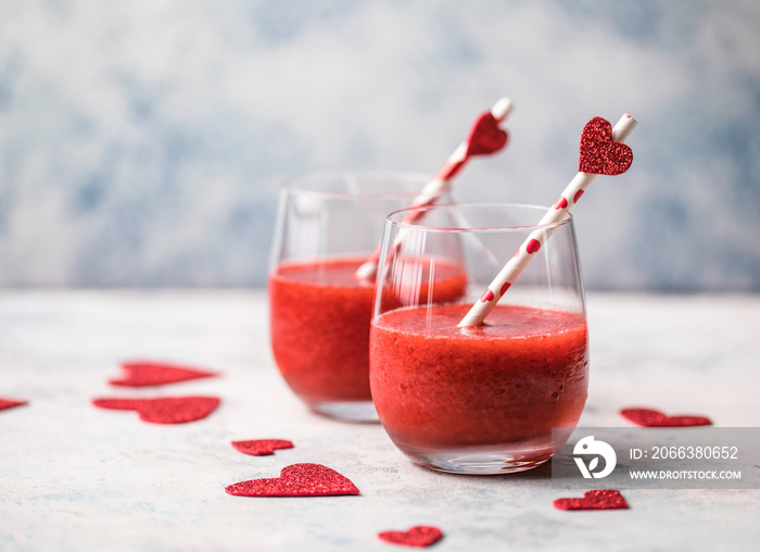 Fresh red strawberry margarita  or daiquiri cocktail with hearts over gray background, valentine day