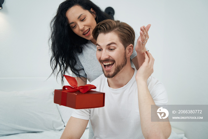 Joyful male getting gift from his romantic partner