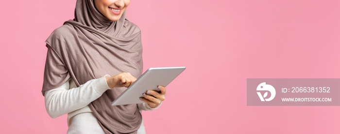 Unrecognizable arabic girl in hijab using digital tablet