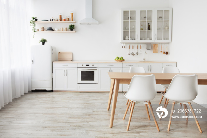 Scandinavian home interior. White kitchen furniture with utensils and dinner table with chairs, empt