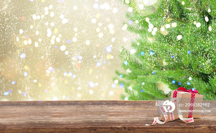 Carton gift boxes on wooden table, border with christmas tree in background