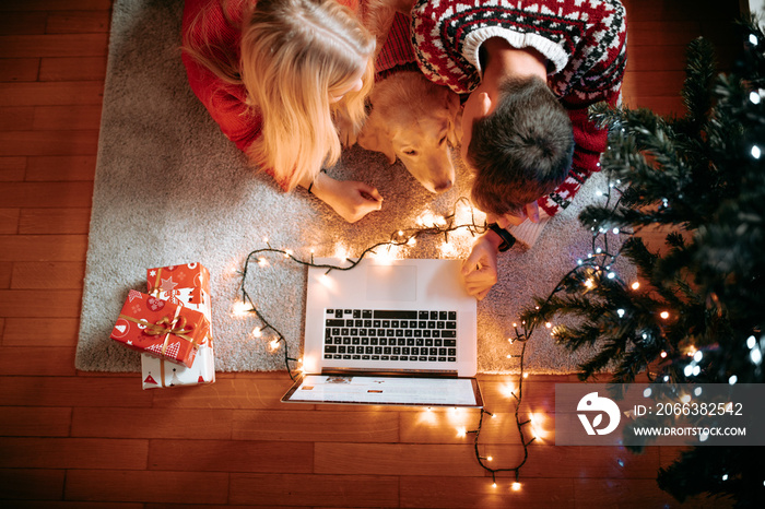 Christmas gifts and happiness between a young couple and a cute dog