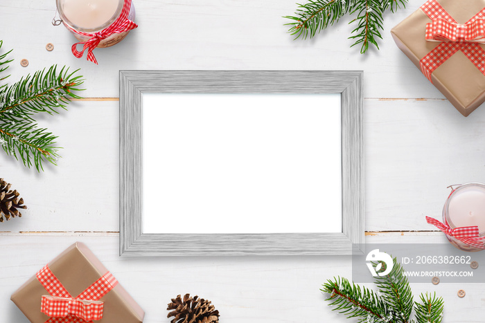 Horizontal photo frame surrounded with Christmas New Year gifts, tree branches and decorations. Isol