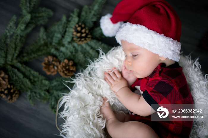 Little baby boy with christmas clothes, sleeping in basket