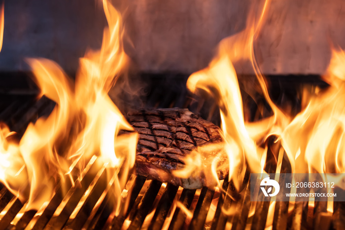 Beef T-bone steaks ( dallas steaks ) on the grill with flames.