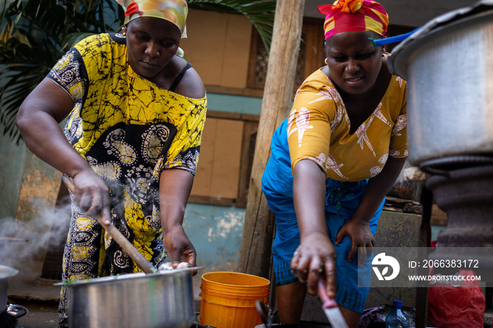 African woman cooking traditional food at street