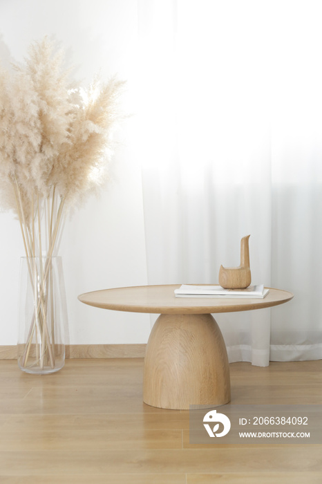 Living room interior in warm  beige tones, coffee table made of solid wood and vase of dried pampas 